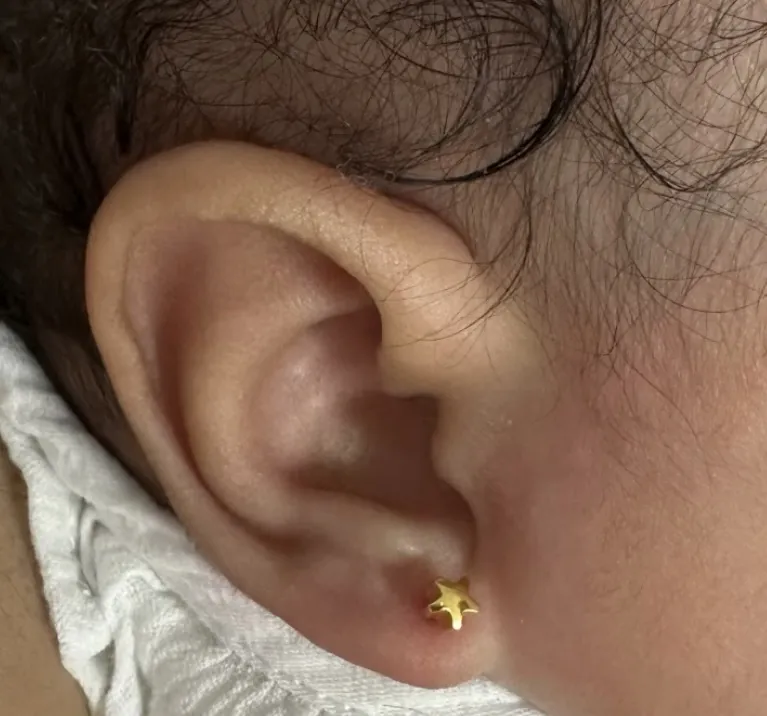 Pendiente de estrella en una oreja de bebé